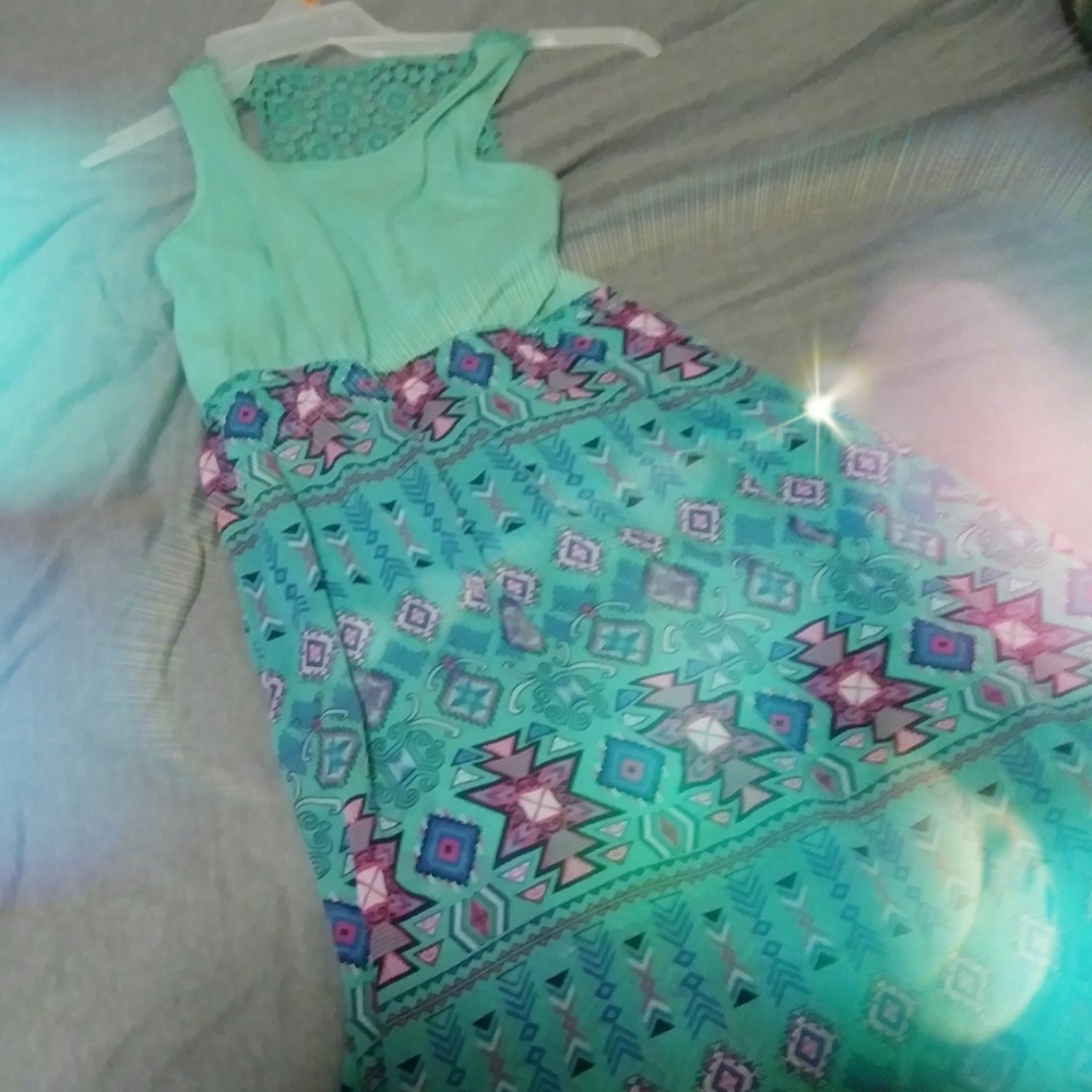 A teal dress with a pattern skirt and a laced back